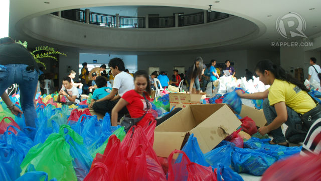 HELP ON THE WAY. Volunteers and government officials in Iloilo City pack relief goods. Photo by Carla Cano/ Rappler