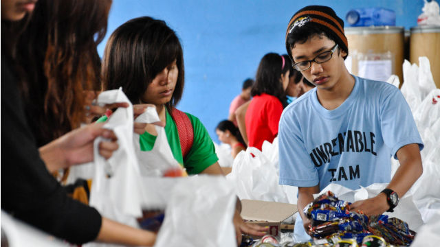 YOUNG FOLKS. Volunteers help repack goods at the DSWD National Resource Operation Center in Pasay City. Photo by Jay Ganzon/Rappler 