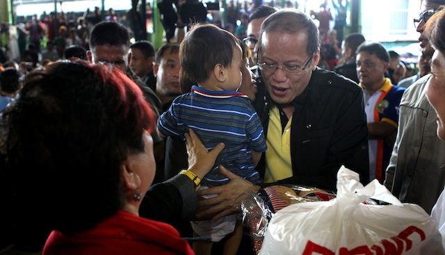 PRESIDENTIAL VISIT. President Benigno Aquino III hands out goods to evacuees in Mandaluyong. Malacañang Photo Bureau