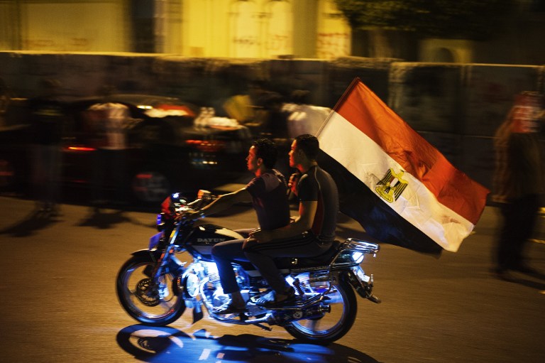 PREPARING FOR 'TAMAROD.' Opponents of the Egyptian president drive past the presidential palace in Cairo waving an Egyptian flag on June 29, 2013. Photo by AFP / Gianluigi Guercia
