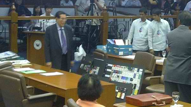 VISUAL AIDS. Senate President Juan Ponce Enrile holds up an illustration board with packs of cigarettes he said were smuggled from abroad. He says the sin tax bill favors foreign manufacturers over local ones because it will worsen smuggling. Photo courtesy of Judee Aguilar/ twitter.com/orangedenims 