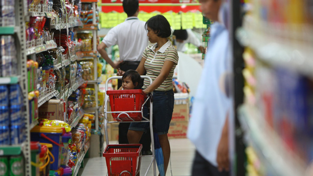 ON NOTICE. A Filipino woman with her daughter in a cart looks at products at a local supermarket. ROLEX DELA PENA/EPA