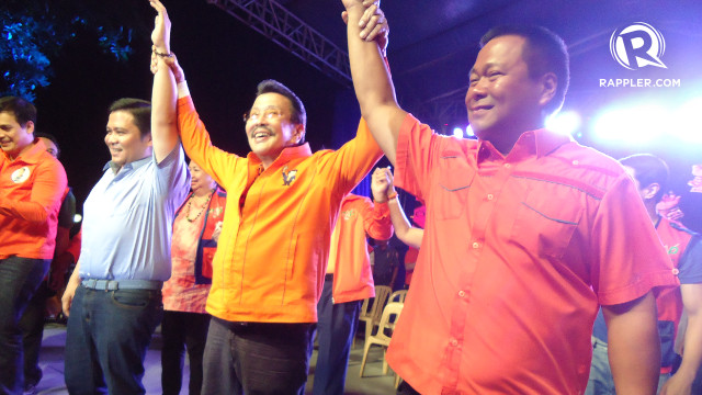 A FATHER'S HAPPINESS. Former President Joseph Estrada flashes a megawatt smile as he raises the hands of his sons, Sen. Jinggoy Estrada and senatorial candidate JV Ejercito. Rappler/Jerald Uy