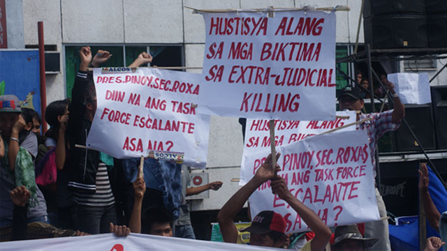 Rally participants display placards calling on President Aquino to immediately act on extrajudicial killings in Escalante. Photo by Gilbert Bayoran