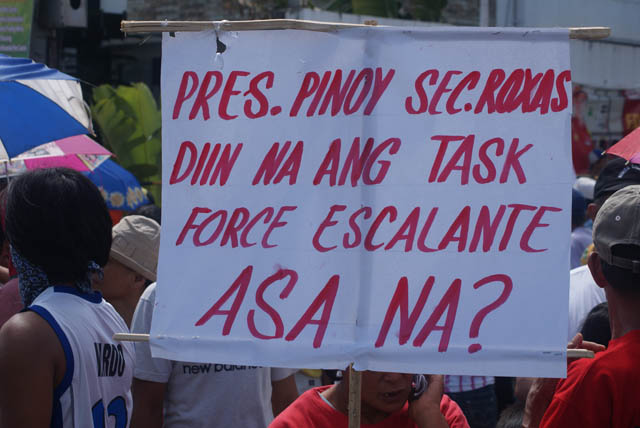 Rally participants display placards calling on President Aquino to immediately act on extrajudicial killings in Escalante. Photo by Gilbert Bayoran
