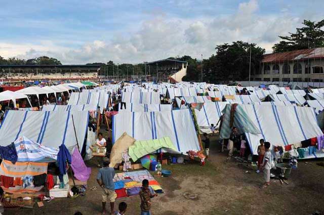 TENT COMMUNITY. Government tents in evacuation centers cannot withstand the heavy rain falling since October 4. File photo by Ted Aljibe/AFP