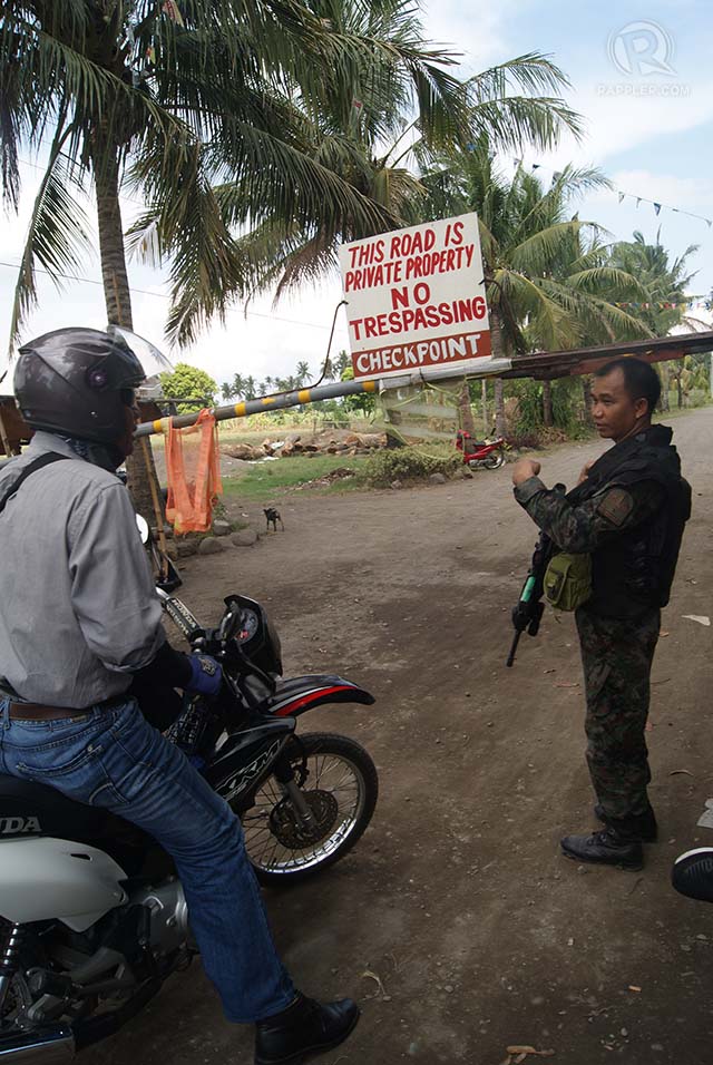 A member of the police elite Special Ation Force checks on motorists going to Brgy. Ubay, Pulupandan. Photo by GILBERT BAYORAN 