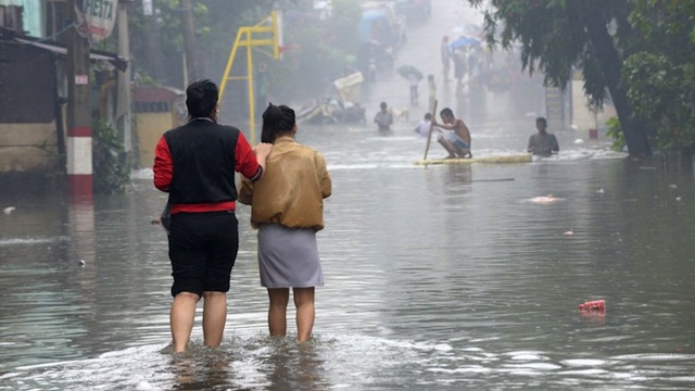 PREDAWN FLASH FLOODS. Residents walk through a flooded street in Manila on September 15, 2012. AFP PHOTO / JAY DIRECTO