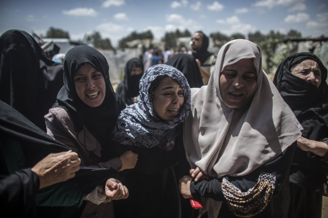 DEATH TOLL RISES. Palestinian women mourn during the funeral of the Abu Muamar family in Khan Younis, southern Gaza Strip, July 14, 2014. File photo by Oliver Weiken/EPA