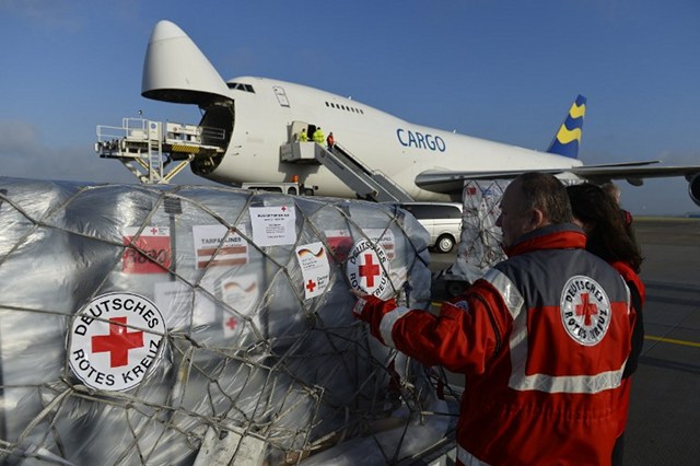 ‘PLETHORA OF AID.’ Helpers of the German Red Cross and of the German technical relief organization THW (Technisches Hilfswerk) load aid packages for the victims of typhoon 'Haiyan' in the Philippines. Photo by Odd Andersen/AFP 