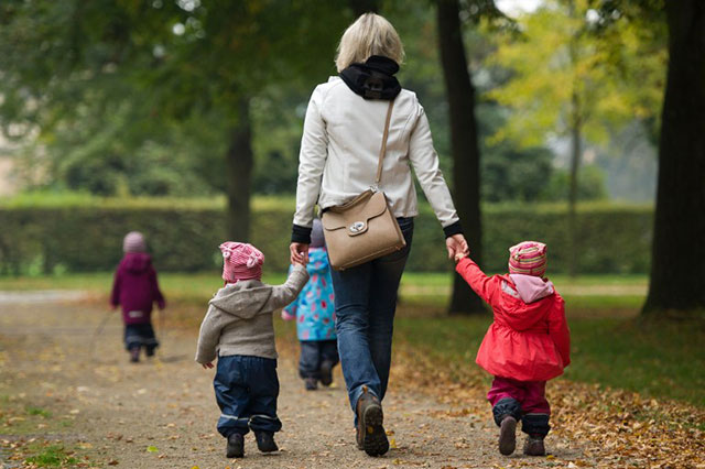 A woman and some toddlers take a stroll through the Grosser Garten park in Dresden, Germany. File photo by Sebastian Kahnert/AFP
