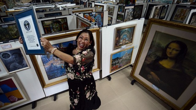 WORLD RECORD. Georgina Gil Lacuna holds up her world record certificate for having the largest collection of jigsaw puzzles. Photo from AFP