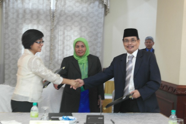 'BIG CHANCE.' Government chief negotiator Miriam Coronel-Ferrer (L) shake hands with Moro Islamic Liberation Front chief negotiator Mohagher Iqbal (R) during the the closing of the 39th round of talks. Looking on is Che Kashna, head of the Malaysian secretariat. Photo by OPAPP