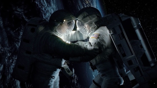 DON'T LET GO. Sandra Bullock (L) and George Clooney, portraying marooned astronauts Ryan Stone and Matt Kowalski, in a scene from "Gravity." Photo courtesy Warner Bros. Pictures