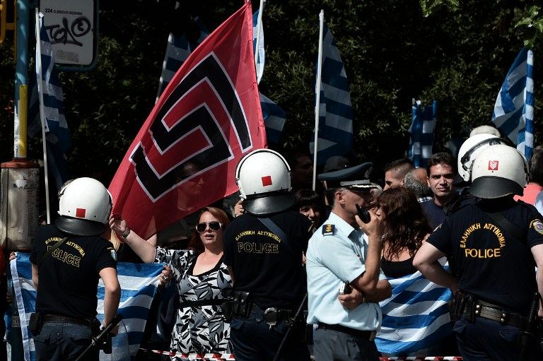 RIGHT-WING SUPPORT. Supporters of Golden Dawn wave the party's flag along with Greek flags during a protest outside a court in Athens on October 2, 2013 as four lawmakers from Greece's neo-Nazi party were indicted for belonging to a criminal organization, a judicial source said. AFP / Aris Messinis
