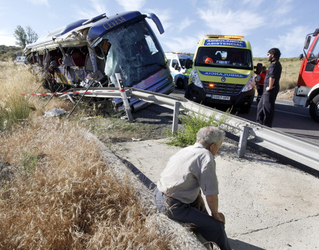 BUS CRASH.  A passenger sits at a verge after a bus crashed at N-403 road near Tornadizos town, some 6 kilometers from Avila city, central Spain. EPA/RAUL SANCHIDRIAN
