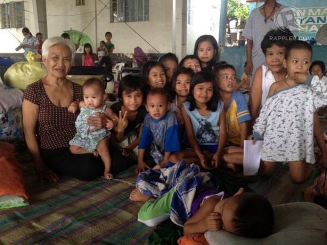 LAUGHING BUT SAD. Rosenda Infante, who has 40 grandchildren (not all in photo), wants a home safer from flooding. Photo by Paterno Esmaquel II