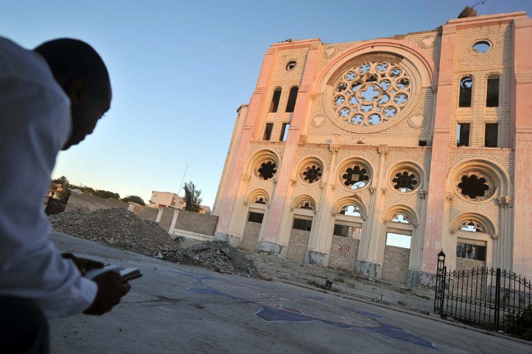 STILL IN RUINS. A man reads the New Testament in front of Cathedral of Port-au-Prince on January 10, 2014. The cathedral was destroyed in the January 12, 2010 earthquake. Hector Retamal/AFP
