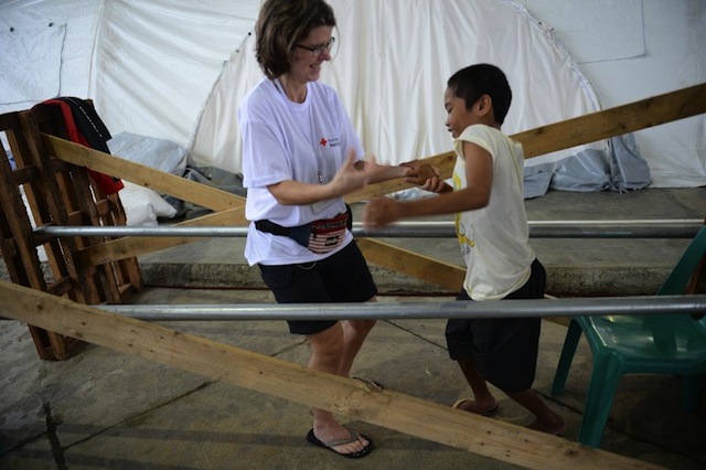 HOPE. In this photo taken on December 24, 2013 Norwegian nurse Janecke Dyvi (L) helps traffic accident victim Mario Renos during a physical rehabilitation session at the 1.6 million USD Red Cross tent hospital in Basey town, Western Samar province, central Philippines. Photo by AFP/Ted Aljibe 