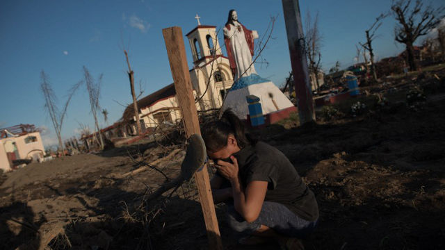 HUMAN COSTS. Marelom Cassanares, 37, with 5 children and no home at the grave of her husband in Palo, Leyte on November 15, 2013. Photo by Nicolas Asfouri/AFP
