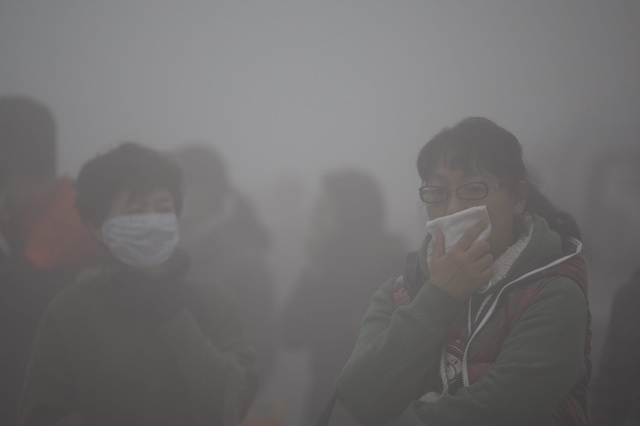 IN THE SMOG. Commuters cover their mouths while waiting for buses in the heavy fog and smog in Harbin, Heilongjiang province, China, 21 October 2013. EPA/Hao Bin