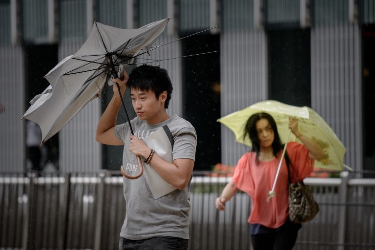 BRACING FOR UTOR. A man holds his broken umbrella against heavy winds in Hong Kong on August 13, 2013 as the city braces for deadly Typhoon Utor (LAbuyo) which earlier swept through the Philippines. Photo by AFP / Philippe Lopez