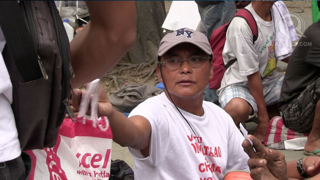 HUNGRY. Former overseas Filipino worker Arthur Villeta asks for food from a charity worker in Liwasang Bonifacio. All photos by David Lozada/ Rappler