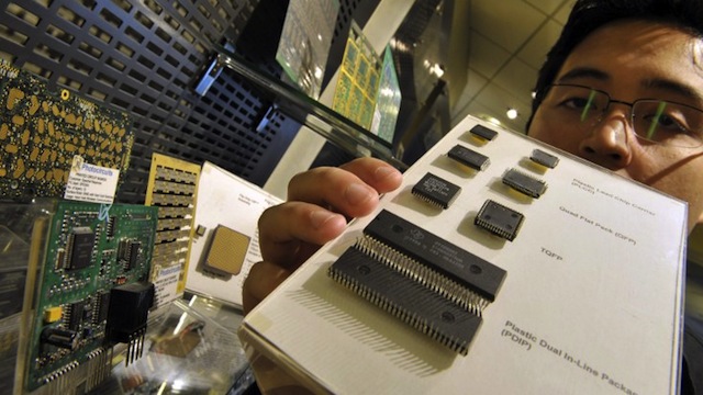 A staff member of the Semiconductor and Electronics Industries in the Philippines shows in their Manila office on December 10, 2008 computer chips manufactured by foreign semiconductor firms in the country. AFP PHOTO/ROMEO GACAD