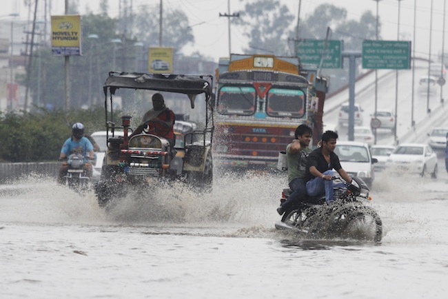FLOODY ROADS. Indian commuters wade through a water logged road during a prolonged spell of pre-monsoon rain in Amritsar, India, 15 June 2013. Photo by Raminder Pal Singh/EPA
