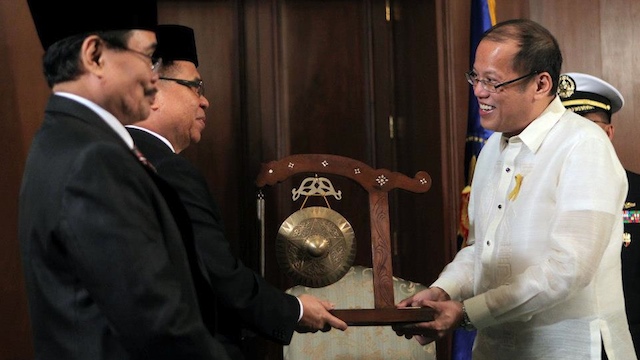 President Benigno Aquino III (right) receives the Gong of Peace from MILF Chairman Al Haj Murad Ebrahim (center). Photo by Malacañang Photo Bureau