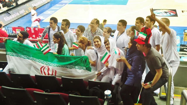 BEHIND THE FLAG. After a convincing victory, Iranian supporters vow to root for their team.