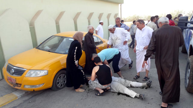 FATALITIES. Iraqis inspect the body of a worshiper who was killed in a bomb attack after the Eid al-Adha prayers in Kirkuk city, northern Iraq. Photo from EPA/Khalil Al-A'nei