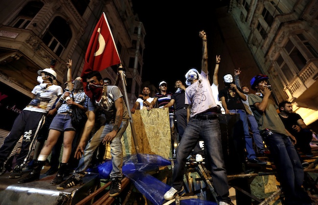 FRESH PROTESTS. Turkish protesters stand on a barricade shouting slogans against government in Taksim Square, in Istanbul, Turkey, 23 June 2013. Photo by EPA/Sedat Suna