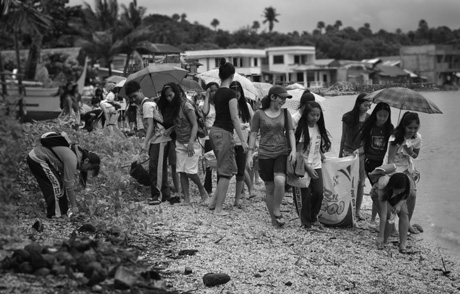 PICKING UP TRASH. Volunteers and kids from Puerto Galera scour the beach to pick trash. Photo by Jadd Padilla