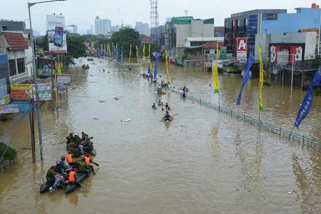 RESCUE. Search and Rescue members rescue stranded people from their flooded houses as residents wade through a flooded street in Jakarta on January 19, 2014. Adek Berry/AFP