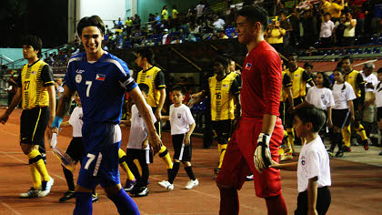 GOOD SPIRITS. James Younghusband shares a smile with Neil Etheridge as they walk to the pitch before the game. February 29, 2012. Emil Sarmiento.
