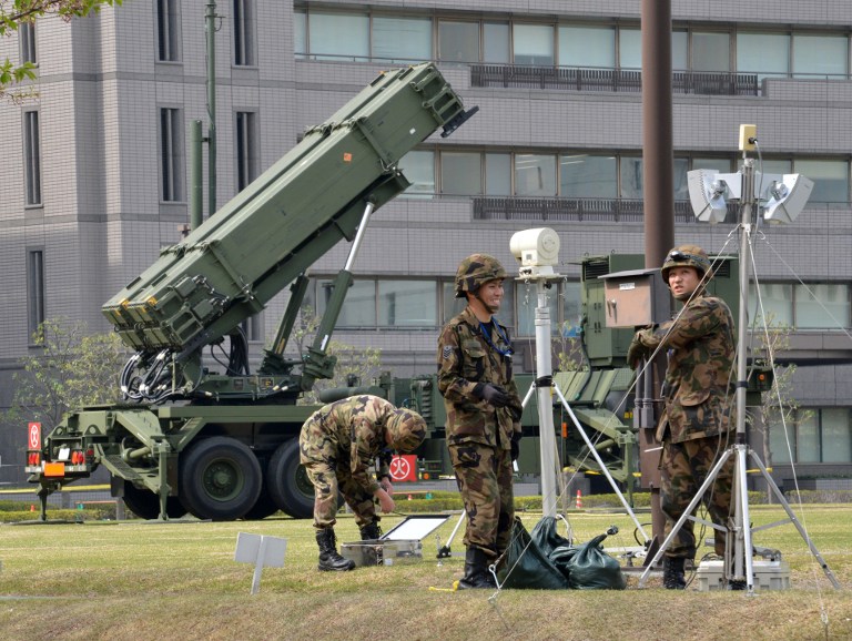Officers of Japan's Ground Self-Defense Force (SDF) work in front of a set Patriot Advanced Capability-3 (PAC-3) missile at the Defence Ministry in Tokyo on April 9, 2013. AFP PHOTO / Yoshikazu TSUNO