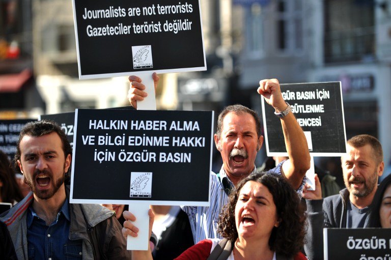 PROTEST. A journalist raises his fist and chants slogans as another holds a sign reading "The public has the right to real news" during a protest calling for media rights in Turkey on November 5, 2013, on the Istiklal Avenue in Istanbul. AFP/Ozan Kose
