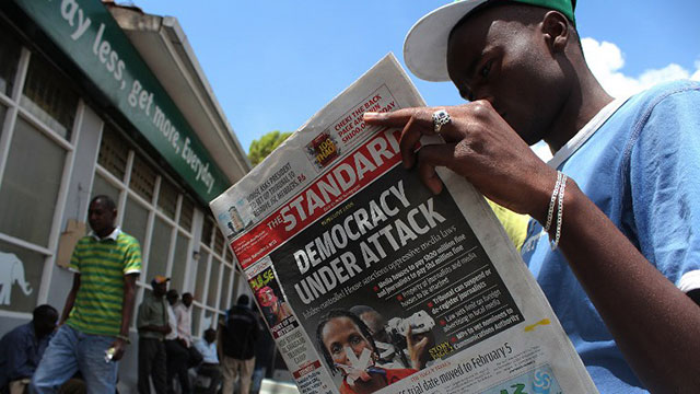 'DEMOCRACY UNDER ATTACK'. Kenya's David Ndirangu reads a local newspaper carrying headlines commenting on a new media bill on November 1, 2013 in Nairobi. Photo by Simon Mania/AFP