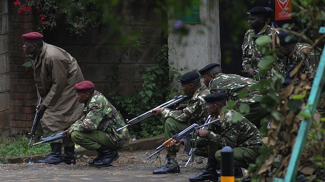 TAKING COVER. Armed Kenyan policemen take cover outside the Westgate mall in Nairobi, on September 23, 2013. AFP/Simon Maina