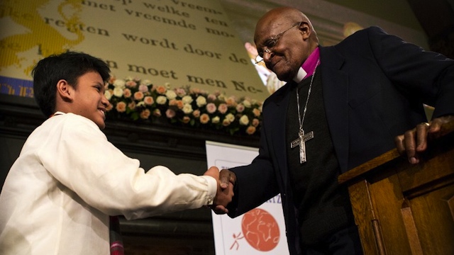 South African Archbishop Desmond Tutu shakes hands with Kesz, 13, after awarding him with the Children's Peace Prize at the Ridderzaal in the Hague on September 19, 2012. AFP PHOTO / ANP / ILVY NJIOKIKTJIEN netherlands out