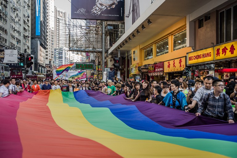 Participants carry a large flag as they take part in a Gay Pride procession in Hong Kong on November 10, 2012. AFP PHOTO / Philippe Lopez