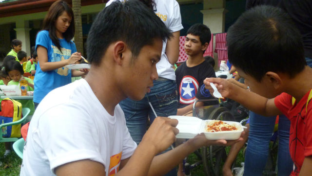 DIFFERENTLY-ABLED. An Ateneo student assists a kid during lunch. Photo by AJ Piquero