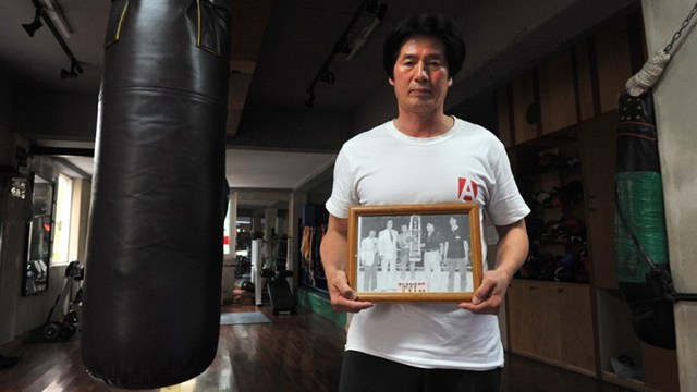 REMEMBERING A FIGHTER. South Korean trainer Kim Yoon-Gu, 56, holds a picture showing boxer Kim Duk-Koo. AFP.