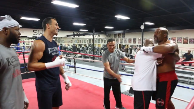 HEAVYWEIGHT DRAMA. Shannon Briggs (R) is restrained by former heavyweight champion Michael Moorer as heavyweight champ Wladimir Klitschko and trainer Johnathan Banks look on. Screen shot from FightNews video