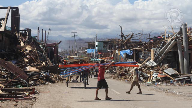 DEVASTATION. A man carries construction supplies across a road in the middle of Cateel, Davao Oriental, in the aftermath of typhoon Pablo (Bopha), December 10, 2012. Photo by Karlos Manlupig.