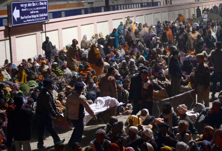Indian authorities carry the bodies of two travellers killed in a stampede at the railway station in Allahabad on February 10, 2013. AFP PHOTO/ ROBERTO SCHMIDT