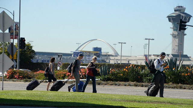 EVACUATION. Passengers carry their bags at Los Angeles International Airport on November 1, 2013 after a gunman reportedly shot 3 people at a security checkpoint. Photo by Robyn Beck/AFP
