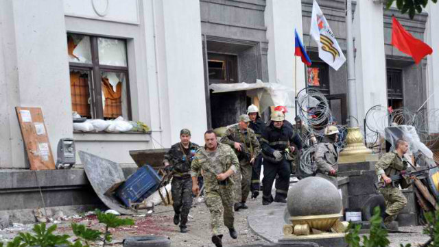 DAY-LONG ASSAULT. Pro-Russian militants and firemen run away as they leave the Regional State building they seized during a shoot-out with Ukrainian border guards defending the Federal Border Headquarters building in the eastern Ukrainian city of Lugansk. Photo by Alex Inoy/AFP