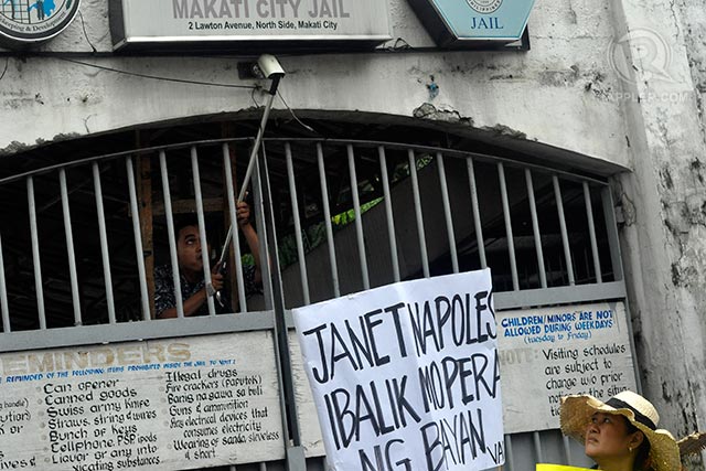 CCTV. A jail guard fixes a CCTV camera while VACC volunteers stage a picket outside the Makati City Jail
